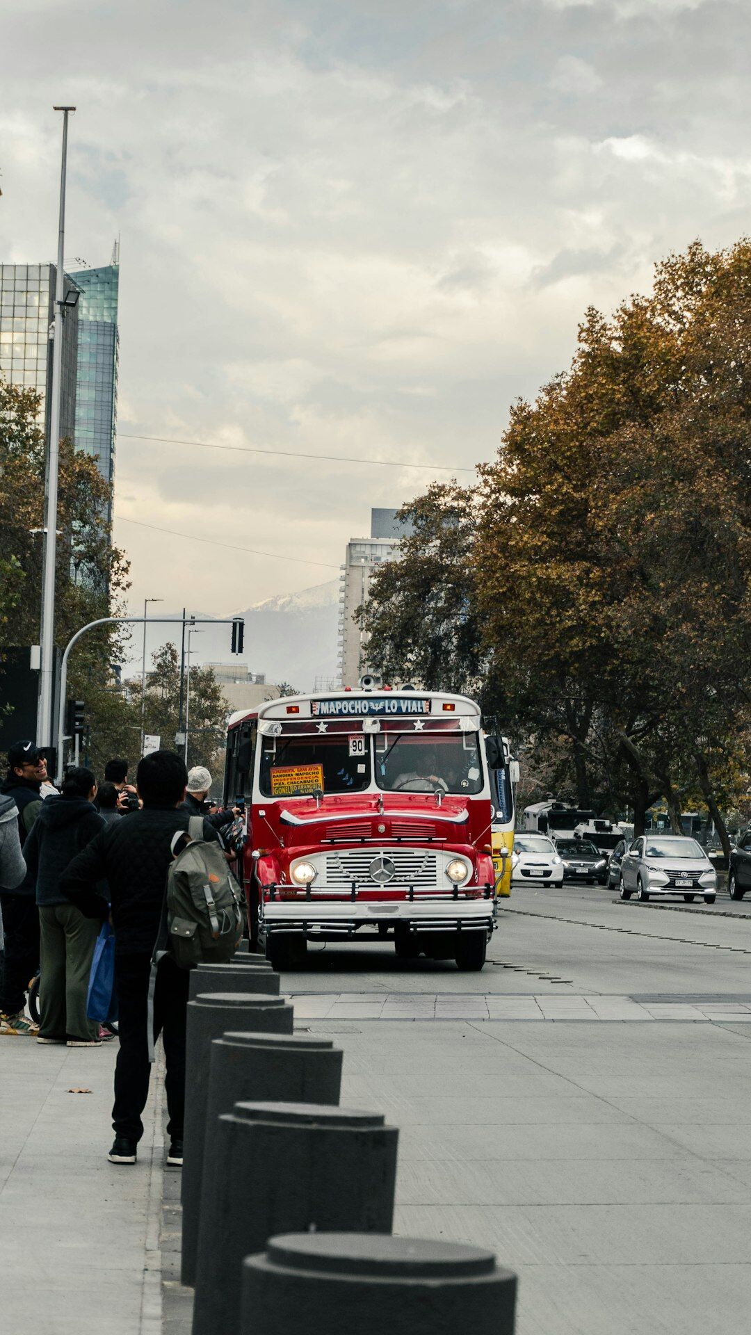 Commuters boarding a public bus on a busy Santiago avenue